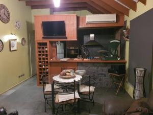une cuisine avec une table et un comptoir avec une télévision dans l'établissement Refugio cordillerano, quincho y piscina, à San Francisco