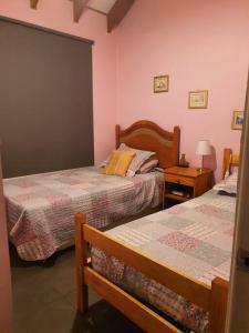 a bedroom with two beds and a table with a lamp at Refugio cordillerano, quincho y piscina in San Francisco