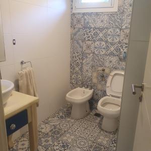 un baño con inodoro y lavabo en Casa con pileta en Pinares de Santa Clara, en Santa Clara del Mar