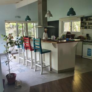 une cuisine avec un comptoir et trois tabourets dans l'établissement Casa con pileta en Pinares de Santa Clara, à Santa Clara del Mar
