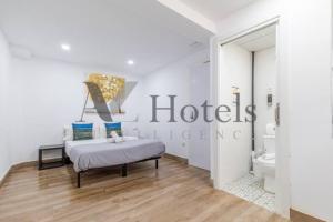 a white bedroom with a bed and a bathroom at A&Z El Cano - Auto check-in property in Málaga