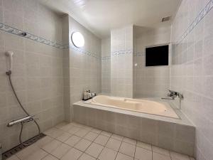 uma casa de banho com banheira e uma televisão em Hotel Asian Color (Adult Only) em Tóquio