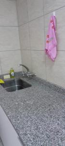 ToayCasa Belén的厨房水槽和墙上的粉红色毛巾