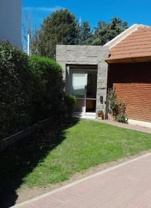 a brick house with a window and a yard at Casa Belén in Toay