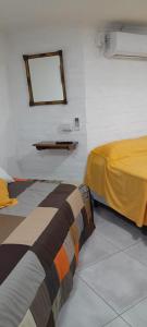 ToayCasa Belén的卧室里有一张床，墙上有一面镜子 更多2张照片
