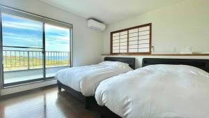 2 camas en un dormitorio con ventana grande en Miyabi-Minami Atami - Vacation STAY 98795v en Atami