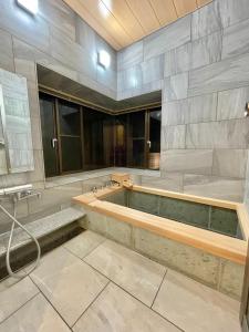 un ampio bagno con vasca e lavandino di Miyabi-Minami Atami - Vacation STAY 98795v ad Atami