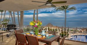 Ocean Front, 3 bedroom, 3 bathroom, Casa Natalia, Playa Esmeralda في بويرتو فايارتا: طاولة على شرفة مطلة على المحيط
