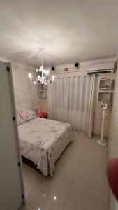 - une chambre avec un lit et un lustre dans l'établissement Residencial Cordeiro, à Balneário Camboriú