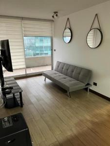 uma sala de estar com um sofá e uma televisão em Las Condes, Apartamento para 4 con Piscina em Santiago