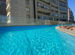 a swimming pool in front of a building at Las Condes, Apartamento para 4 con Piscina in Santiago