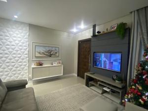 a living room with a christmas tree and a television at Casa com piscina em itapema in Itapema