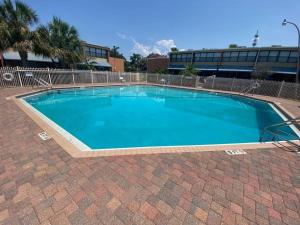 una gran piscina azul en un edificio en Gulf Breeze Condo w Pool Access!, en Gulf Breeze