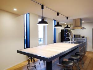 a kitchen with a large island with bar stools at HakoBA Hakodate by THE SHARE HOTELS in Hakodate