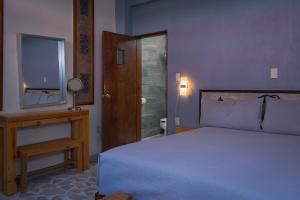 a bedroom with a bed and a television and a table at Hotel Corazón de Plata Centro in Guanajuato