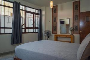 1 dormitorio con 1 cama, ventanas y ventilador en Hotel Corazón de Plata Centro en Guanajuato