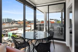 a balcony with a glass table and chairs at Boutique Stays - Camillea in Melbourne
