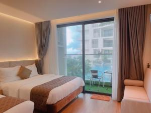 um quarto de hotel com duas camas e uma grande janela em Apec mandala one phú yên em Liên Trì (3)