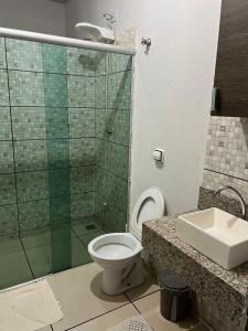 a bathroom with a shower and a toilet and a sink at Hostel Jotaaa F in Ourinhos