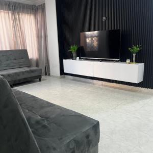 uma sala de estar com uma televisão de ecrã plano num armário branco em Apartamentos San José em Cartagena de Indias