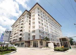 a large white apartment building in a parking lot at RFR Condo Suites in Bacolod