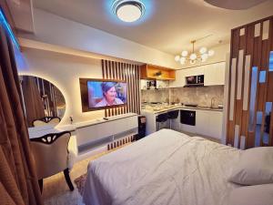 a bedroom with a bed and a tv on a wall at RFR Condo Suites in Bacolod