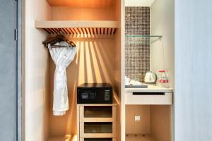 einen Schrank mit einer Mikrowelle und einem Waschbecken in der Unterkunft Yiwu International Mansion in Yiwu
