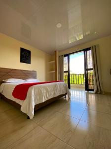 a bedroom with a bed and a large sliding glass door at Hotel Casa campestre HH in Quimbaya