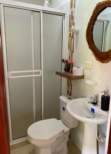 y baño con aseo y lavamanos. en Hotel Casa campestre HH en Quimbaya