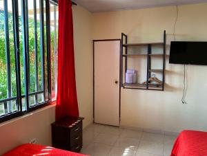 1 dormitorio con puerta y cortina roja en Hotel Casa campestre HH, en Quimbaya