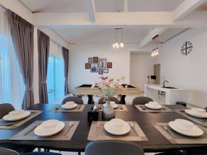 una sala da pranzo con tavolo e sedie e una sala da pranzo di Niyham Pool Villa a Bang Phli
