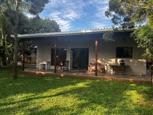 a house with a patio and a yard at Palm Tree Cottage Felixton in Richards Bay