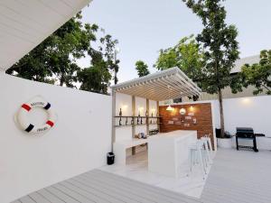 un patio blanco con una pelota de voleibol y una mesa en Niyham Pool Villa, en Bang Phli