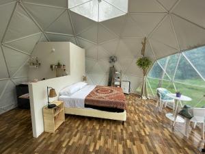 マヌエル・アントニオにあるLa Comarca River Glamping Dome near Manuel Antonioのベッドとテーブル付きのドームテント内のベッドルーム1室