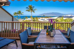 a table on a balcony with a view of the beach at Luxurious & Spacious Ocean Vistas in Wailea