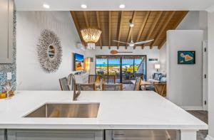 a kitchen with a sink and a living room at Luxurious & Spacious Ocean Vistas in Wailea