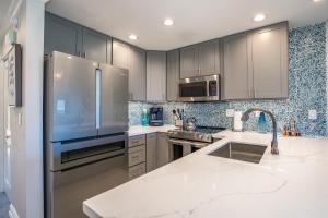 a kitchen with stainless steel appliances and gray cabinets at Luxurious & Spacious Ocean Vistas in Wailea