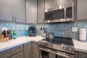 a kitchen with a stove and a microwave at Luxurious & Spacious Ocean Vistas in Wailea