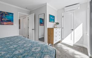 a bedroom with a bed and a dresser and mirror at Luxurious & Spacious Ocean Vistas in Wailea