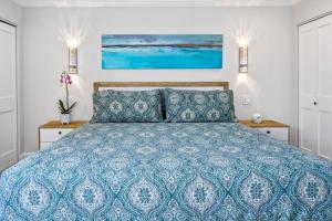 a bedroom with a blue bed with two night stands at Luxurious & Spacious Ocean Vistas in Wailea