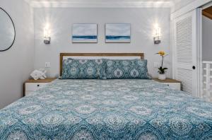 a bedroom with a bed with a blue comforter at Luxurious & Spacious Ocean Vistas in Wailea