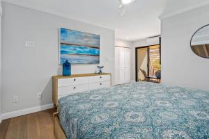 a bedroom with a bed and a painting on the wall at Luxurious & Spacious Ocean Vistas in Wailea
