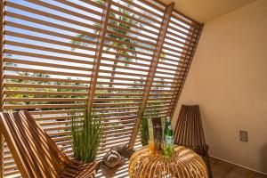 a dining room with a large window with wooden blinds at Luxurious & Spacious Ocean Vistas in Wailea