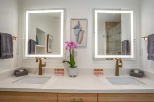 two sinks in a bathroom with two mirrors at Luxurious & Spacious Ocean Vistas in Wailea