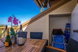 a patio table with a bottle of wine and flowers on it at Luxurious & Spacious Ocean Vistas in Wailea
