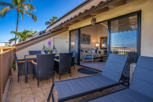 a patio with chairs and a table on a balcony at Luxurious & Spacious Ocean Vistas in Wailea
