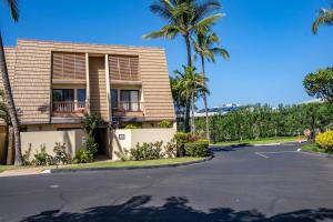 a building with palm trees in front of a parking lot at Luxurious & Spacious Ocean Vistas in Wailea
