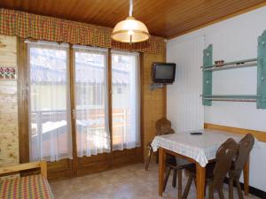 a dining room with a table and a television at Charmant 2 pièces au cœur des Gets, proche télécabines, balcon, Wi-Fi, garage, animaux bienvenus - FR-1-671-137 in Les Gets