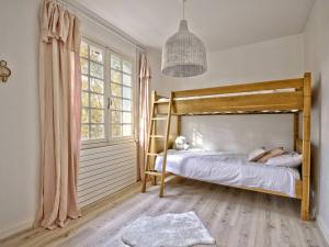 1 dormitorio con litera de madera y ventana en Villa Pyla-sur-Mer, 3 pièces, 4 personnes - FR-1-433-111, en La Teste-de-Buch