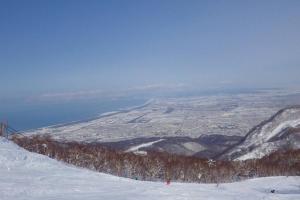 a group of people skiing down a snow covered slope at 手稲本町一軒家 in Sapporo